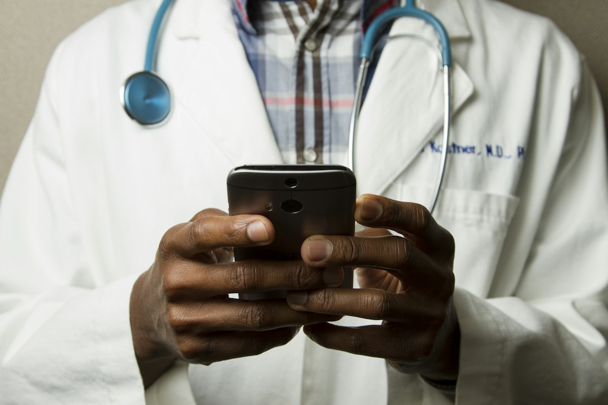 Doctor in white coat using a phone